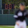 Derrière un joueur sur un terrain de baseball, un cadran géant affiche une seconde restante.