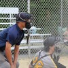 Un arbitre de baseball regarde un lancer derrière le receveur.