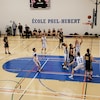 Joueurs sur un terrain de basket de l'école secondaire Paul-Hubert de Rimouski.