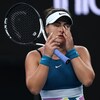 La joueuse de tennis Bianca Andreescu porte ses mains à son visage.