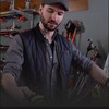 Photo du biathlonien Jean-Philippe LeGuellec dans un atelier en train de farter des skis de fond.