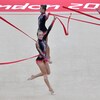Quatre gymnastes font des figures avec des rubans rouges