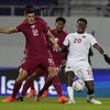 Jonathan David du Canada et Karim Boudiaf du Qatar se disputent le ballon.