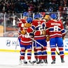 Des joueurs de hockey célèbrent un but. 