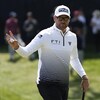 Le golfeur Corey Conners tient une balle dans sa main droite.