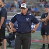 Un homme est debout sur les lignes de côté d'un terrain de football.