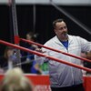 Un entraîneur surveille une athlète lors d'une compétition de gymnastique.