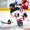Le parahockeyeur Dominic Cozzolino contrôle la rondelle.