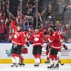 Des hockeyeurs canadiens célèbrent un but sur la patinoire.