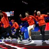 Tous vêtus de rouge, les membres de l'équipe mondiale, y compris l'entraîneur John McEnroe, sautent de joie et s'apprêtent à envahir le terrain après la victoire décisive de Frances Tiafoe.