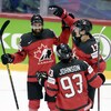 Trois hockeyeurs canadiens célèbrent un but.