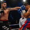 Un boxeur frappe un adversaire de sa main gauche.