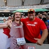 L'athlète, qui tient un drapeau du Canada sur ses épaules, pose avec son entraîneur.