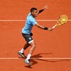 Il joue au tennis sur terre battue.