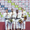 Quatre judokas présentent leur médaille.