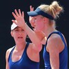 Deux joueuses de tennis lèvent leurs bras pendant un match.