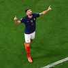 Un joueur de soccer regarde vers le ciel avec les bras en l'air.