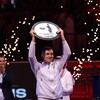 Un joueur de tennis soulève la plaque de champion d'un tournoi.