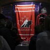 Dans le noir, des partisans imperceptibles font la file pour accéder à une boutique qui vend des produits dérivés de Hockey Canada. 
