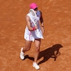 Une joueuse de tennis sourit et tient sa raquette dans sa main droite.