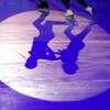 Les ombres de patineurs artistiques durant une compétition.