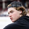 Un jeune joueur porte des écouteurs et une casquette.