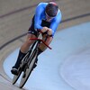 Un cycliste sur piste performe lors d'une compétition.