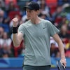 Le joueur de tennis lève le poing droit d'un air sévère.