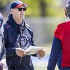 Un entraîneur de football parle avec un joueur à l'entraînement. 