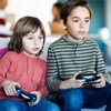 Deux enfants jouent à un jeu vidéo dans un salon. 