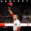 Joey Votto lève son casque en l'air pour saluer les amateurs de baseball à Cincinnati.