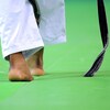 Un judoka marche sur un tatami.