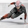 Elle effectue un virage, main apposée sur la glace. 