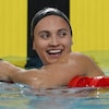 Une nageuse sourit après avoir gagné une course.