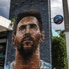 Le visage d'un homme apparaît sur un mur de briques.