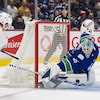 Un gardien de but de hockey réalise un arrêt spectaculaire. 