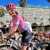 La cycliste pose pour la photo, debout sur son vélo. 
