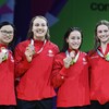 Quatre femmes présentent leur médaille.