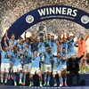 Une équipe championne de soccer soulève le trophée. 