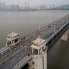 Des marathoniens courent sur un pont.