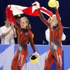 Les deux patineurs brandissent le drapeau canadien