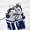 Deux hockeyeurs s'enlacent après un but.