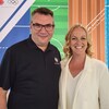Un homme et une femme se tiennent côte à côte et sourient.