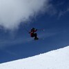 Une skieuse réalise un saut.