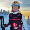 Miha Fontaine tenant ses skis et posant sur la montagne.