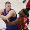 Un basketteur contrôle le ballon devant un adversaire qui le surveille étroitement.
