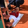 Un joueur de tennis étendu reçoit des traitements d'un thérapeute. 