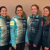 Quatre femmes souriantes se tiennent debout dans leur manteau d'équipe Nunavut.