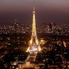 La tour Eiffel, illuminée en soirée, trône au coeur de la ville.