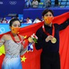 Deux patineurs artistiques chinois avec leur médaille d'or olympique.